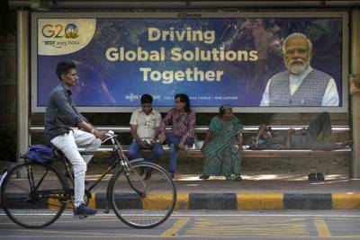 A cyclist rides past a bus stop with a poster of Indian Prime Minister Narendra Modi ahead of this week's summit of the Group of 20 nations in New Delhi, India. AP Photo