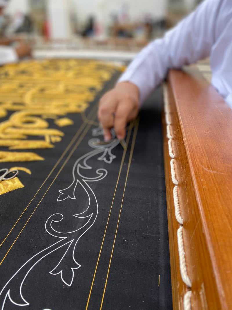 Writings, decoration and calligraphy are first printed on the plain black clothes before embroidered on them.