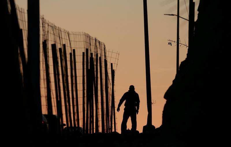 TIJUANA, MEXICO - JANUARY 7: A man walks along a road next to the U.S.-Mexico border wall on January 7, 2019 in Tijuana, Mexico. President Donald Trump, who is planning on visiting the border on Thursday, is considering declaring a national emergency if Democrats do not approve of 5.7 billion dollars in funding to build a wall. (Photo by Sandy Huffaker/Getty Images) ***BESTPIX***