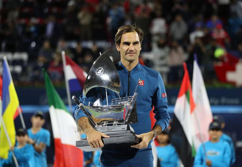 Switzerland's Roger Federer celebrates with the trophy after winning the final match at the ATP Dubai Tennis Championship in the Gulf emirate of Dubai on March 2, 2019. Roger Federer won his 100th career title when he defeated Greece's Stefanos Tsitsipas 6-4, 6-4 in the final of the Dubai Championships. / AFP / KARIM SAHIB
