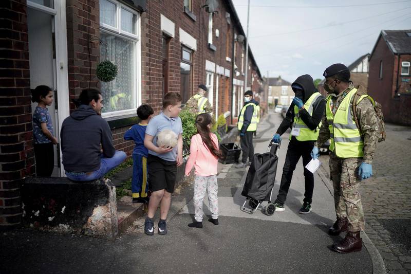 Children play in the street as gunners from the Royal Horse Artillery distribute Covid-19 PCR tests to local residents in Bolton. Getty Images