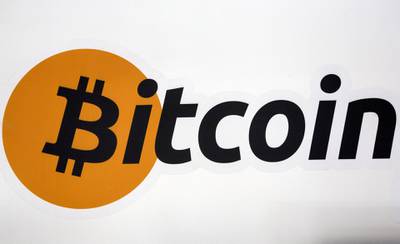 FILE PHOTO: A Bitcoin logo is displayed at the Bitcoin Center New York City in New York's financial district in NY, U.S. on July 28, 2015. REUTERS/Brendan McDermid/File Photo