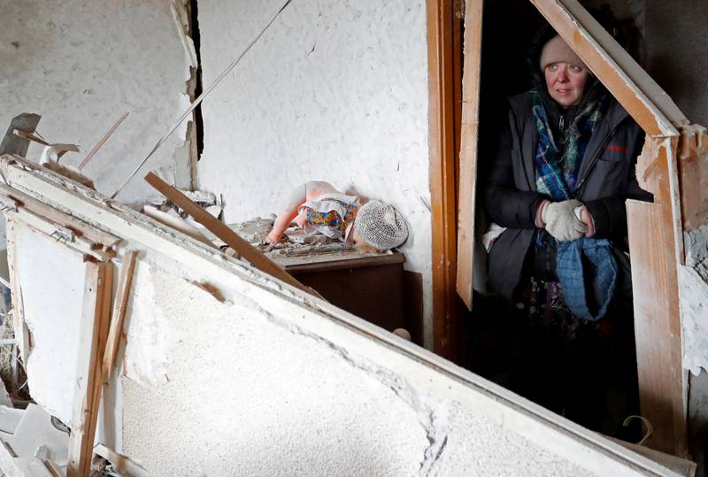 A resident assesses her damaged flat in Mariupol. Reuters
