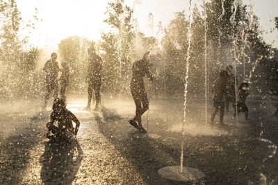 Children keep cool on a fountain at the Stavros Niarchos Foundation Cultural Centre in Athens, Greece. AP 