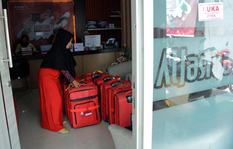 A travel agency officer tidies up suitcases owned by Umrah pilgrims, after the cancellation of the departure to Mecca following the Saudi government's temporary ban to keep the country safe because of coronavirus outbreak, in Makassar, Sulawesi Selatan, Indonesia. Reuters
