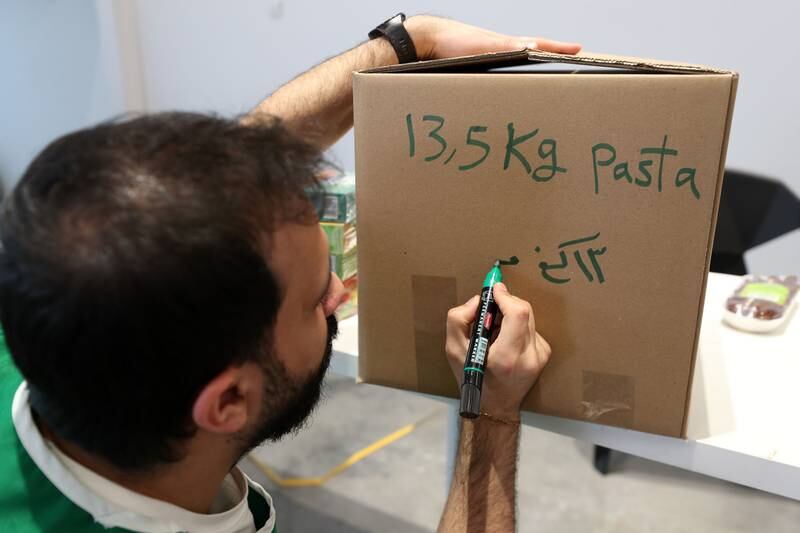 Volunteer Abdo Hwija labels pasta boxes bound for earthquake-hit Turkey and Syria. 

