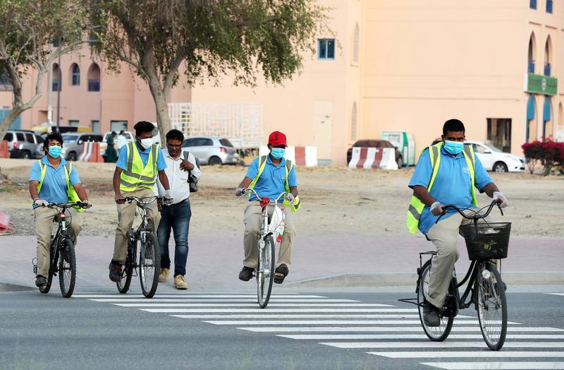 DUBAI, UNITED ARAB EMIRATES , April 18– 2020 :- Staff members of INAYA, facilities management company wearing protective face mask in International City in Dubai. Only two entrance are open for vehicles coming from Al Awir road before the Dragon Mart 1 and Manama Street to International City in Dubai.  Dubai is conducting 24 hours sterilisation programme across all areas and communities in the Emirate and told residents to stay at home. UAE government told residents to wear face mask and gloves all the times outside the home whether they are showing symptoms of Covid-19 or not.  (Pawan Singh / The National) For News/Online