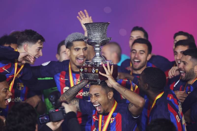 Barca's Raphinha celebrates with the Spanish Super Cup
after their 3-1 victory against Real at King Fahd International Stadium on January 15, 2023 in Riyadh, Saudi Arabia. Getty