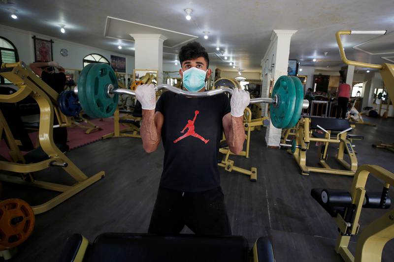 A man lifting weights trains in a gym as Palestinians ease coronavirus restrictions, in Gaza City. Reuters
