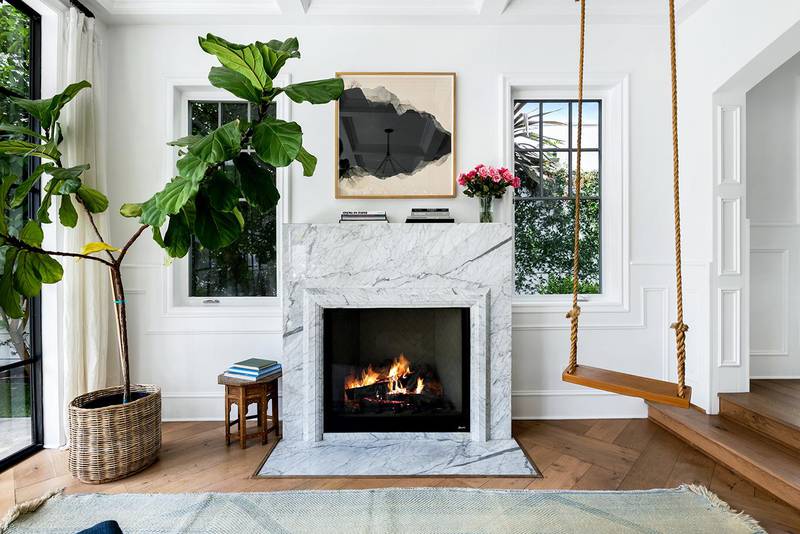 The property has a light grey marble fireplace, with a swing in the living room. Courtesy Engel & Volkers