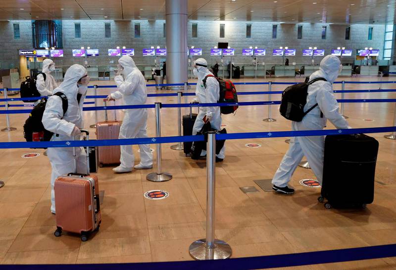 Chinese passengers wearing full protective suits and masks to protect against the COVID-19 pandemic push their luggage trolleys at the departures area at Ben-Gurion Airport in Lod, near the Israeli city of Tel Aviv.  AFP