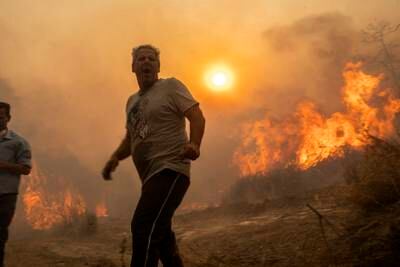 Residents of Gennadi village stand near a forest fire raging on the island of Rhodes. AP