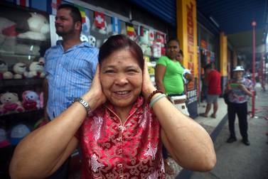 A member of the Panamanian-Chinese community protects her ears from the noise during the Chinese Lunar New Year celebrations in Panama City on February 16, 2018. Rodrigo Arangua / AFP
