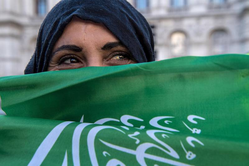 A woman holds the flag of Saudi Arabia outside No 10 as Prince Mohammed visited Mrs May. Getty Images