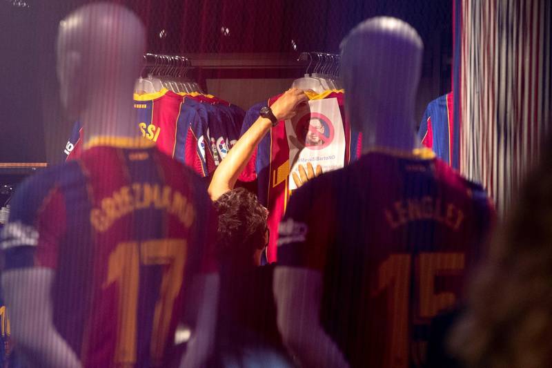 A protester places a banner on a t-shirt at the Barcelona  club shop. EPA