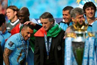 Although he played a vital part in rejuvenating Manchester City's strong finish to the season, Carlos Tevez, left, is likely to be moved on by Roberto Mancini, right, if the club's valuation is met. Paul Ellis / AFP