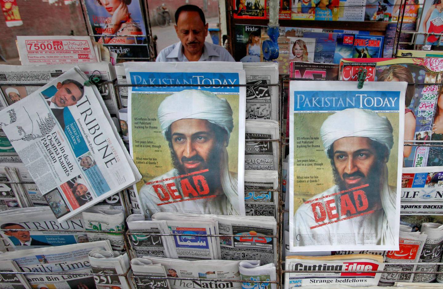 FILE PHOTO: A roadside vendor sells newspapers with headlines about the death of al Qaeda leader Osama bin Laden, in Lahore May 3, 2011.  REUTERS/Mohsin Raza/File Photo