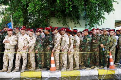 Iraqi security members line up outside a polling station waiting to cast their vote, two days before polls open to the public in a parliamentary election in Baghdad. Thaier al-Sudani / Reuters