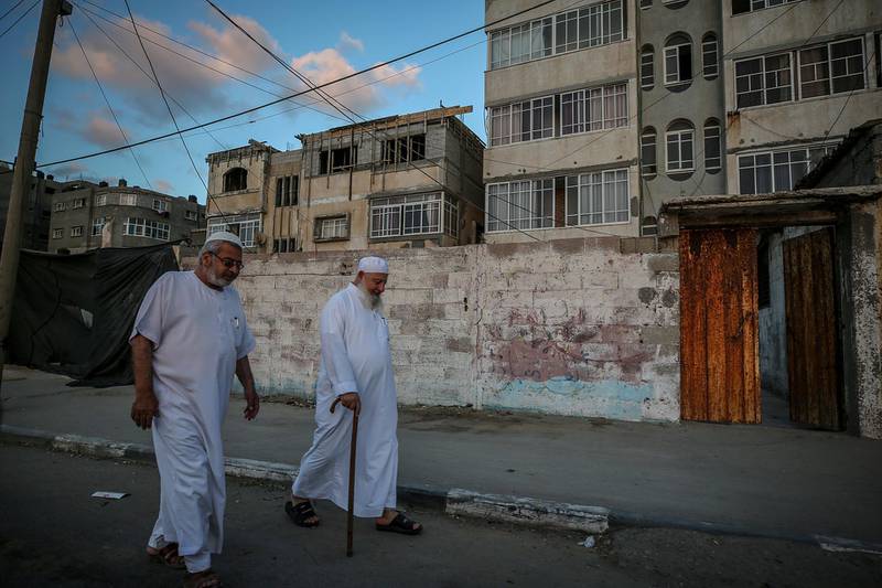 Palestinian elderly men walk on a street in Al Shatea refugee camp, amid the ongoing pandemic in Gaza City.  EPA