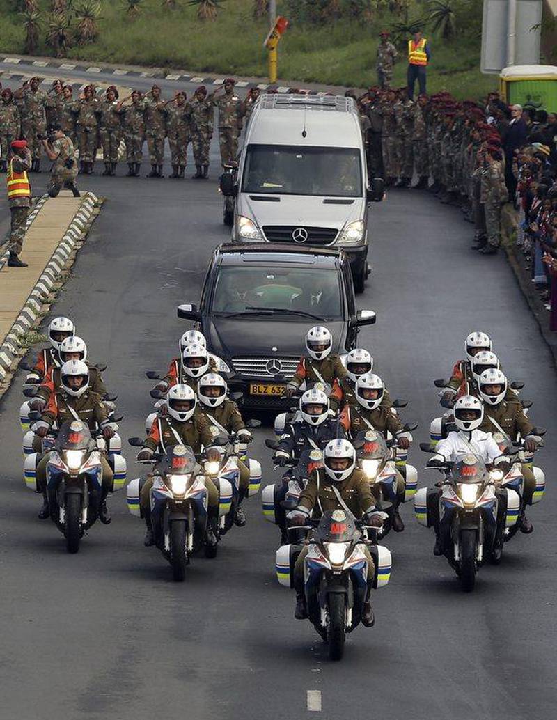 Defense force personnel and hospital staff salute the procession for former South African president Nelson Mandela as it leaves the military hospital in Pretoria. Themba Hadebe / AP Photo