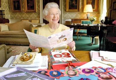 HM Queen Elizabeth II sits in the Regency Room at Buckingham Palace in London, April 20, 2006, as she looks at some of the cards which have been sent to her for her 80th birthday. (Photo by Anwar Hussein Collection/ROTA/WireImage)