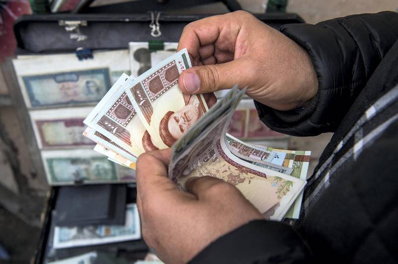 A currency trader counts Iranian rial banknotes at a money exchange market in Iran. Photographer: Ali Mohammadi/Bloomberg