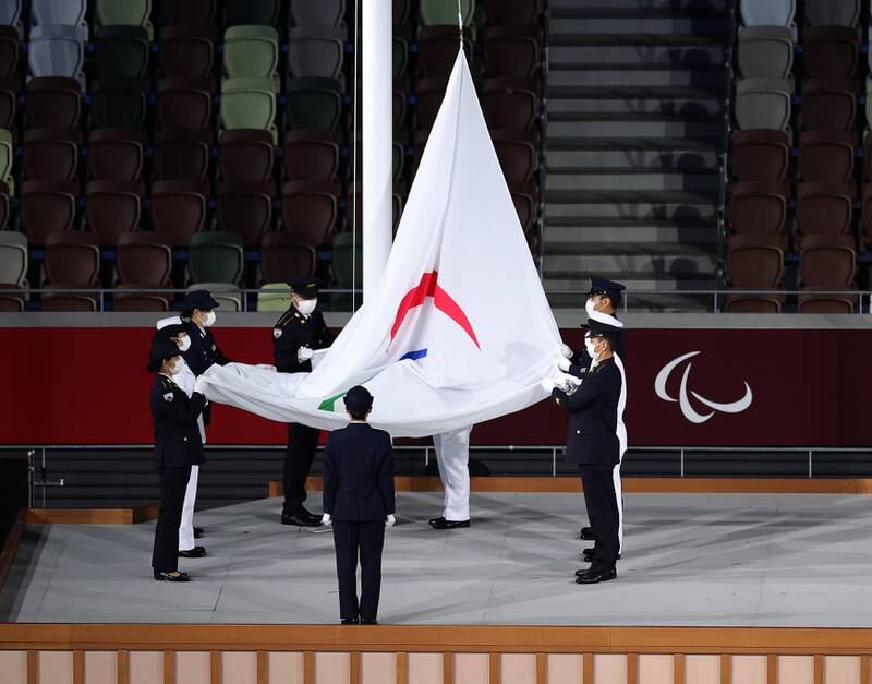 The Paralympic flag is lowered during the ceremony. Getty