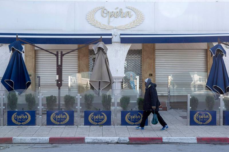 A man walks past a closed cafe in La Marsa, outside Tunis. AP Photo