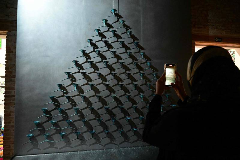 A visitor takes a photo of 'Fountain of Exhaustion' by artist Pavlo Makov at Ukraine's pavilion, on a press day ahead of the 59th Venice Art Biennale in Venice on April 19, 2022.  - Eighty countries, including Ukraine, will have a pavilion at the 59th Biennale, which is set to begin on April 23 and runs through November.  (Photo by Vincenzo PINTO  /  AFP)  /  RESTRICTED TO EDITORIAL USE - MANDATORY MENTION OF THE ARTIST UPON PUBLICATION - TO ILLUSTRATE THE EVENT AS SPECIFIED IN THE CAPTION