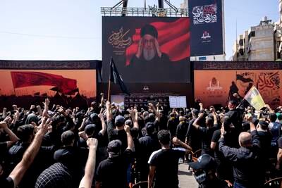 A crowd of Shiite Muslim worshippers in Beirut watch Hezbollah Secretary General Hassan Nasrallah's video address on the holy day of Ashoura on Saturday. AP
