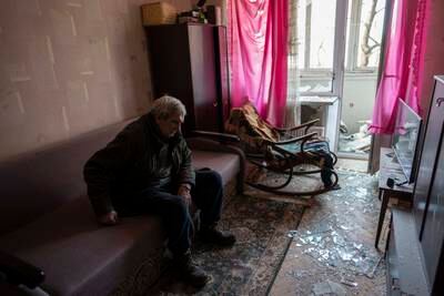Volodymyr, 80, rests inside his apartment, which was damaged by shelling, in Kyiv. AP