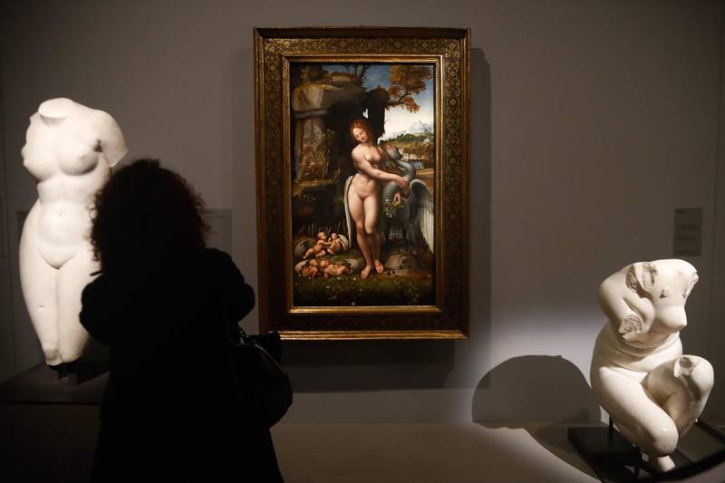 A person looks at a painting by Leonardo da Vinci's  "  Leda and the Swan " during the opening of the exhibition " Leonardo da Vinci ", at the Louvre museum in Paris.