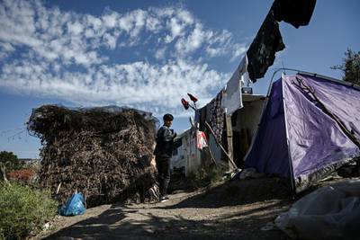 A boy walks in a improvised tents camp near the refugee camp of Moria in the island of Lesbos on June 21, 2020. - Greece's announcement that it was extending the coronavirus lockdown at its migrant camps until July 5, cancelling plans to lift the measures on June 22, coincided with World Refugee Day on June 27, 2020. (Photo by ARIS MESSINIS / AFP)