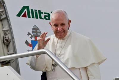 Pope Francis waves as he boards the airplane for Abu Dhabi, at Rome's Fiumicino International airport. AP Photo