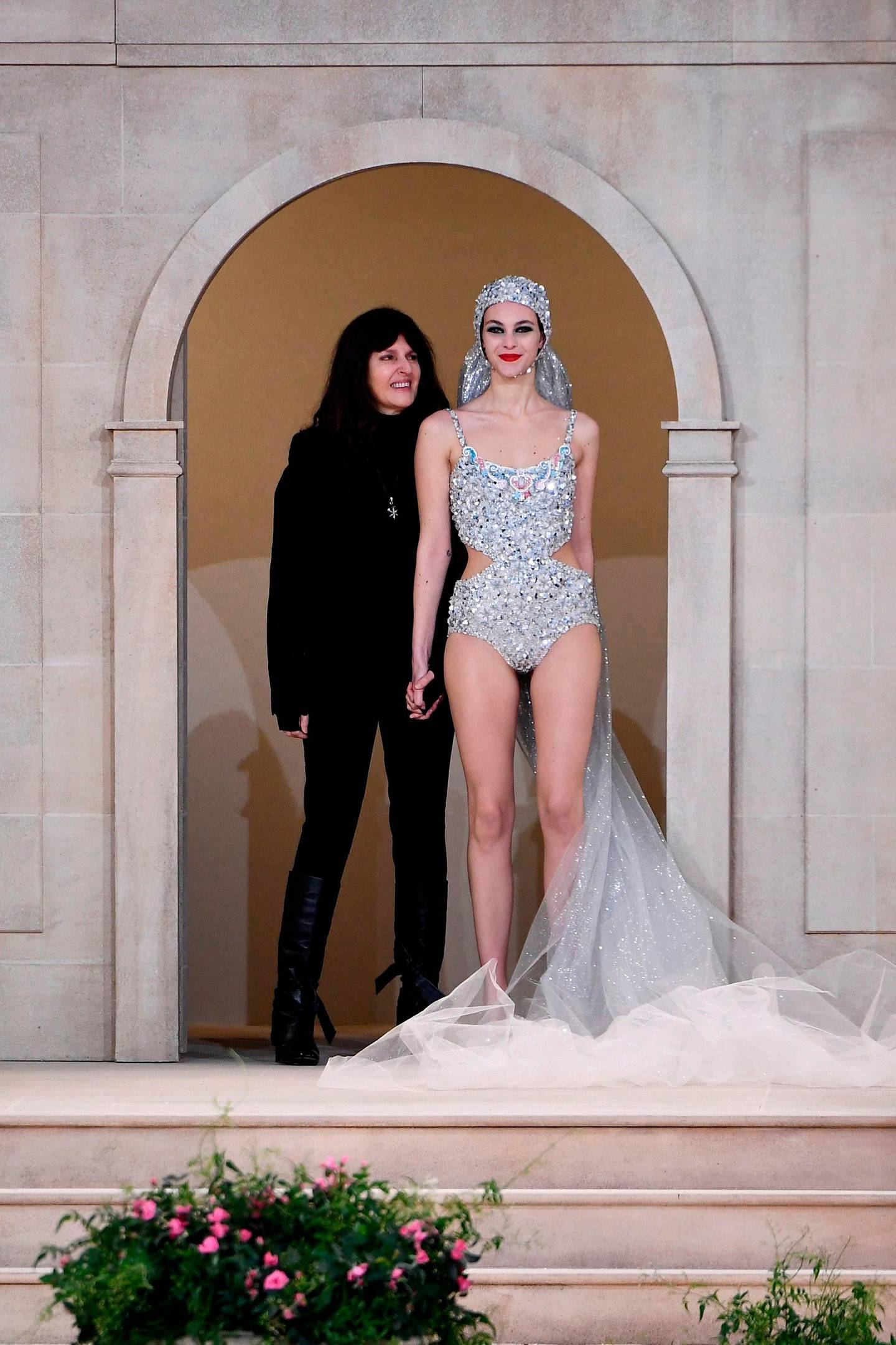 (FILES) In this file photo taken on January 22, 2019 French fashion studio director of Chanel Virginie Viard (L), flanked by Italian model Vittoria Ceretti, acknowledges the audience at the end of the Chanel Spring-Summer 2019 Haute Couture collection fashion show at the Grand Palais in Paris. Virginie Viard, Lagerfeld's right hand person, will be the successor of late German designer Karl Lagerfeld, and will become the fashion designer of Chanel according to a statement of the French fashion house. German fashion designer Karl Lagerfeld has died at the age of 85, it was announced on February 19, 2019.  / AFP / Anne-Christine POUJOULAT            
