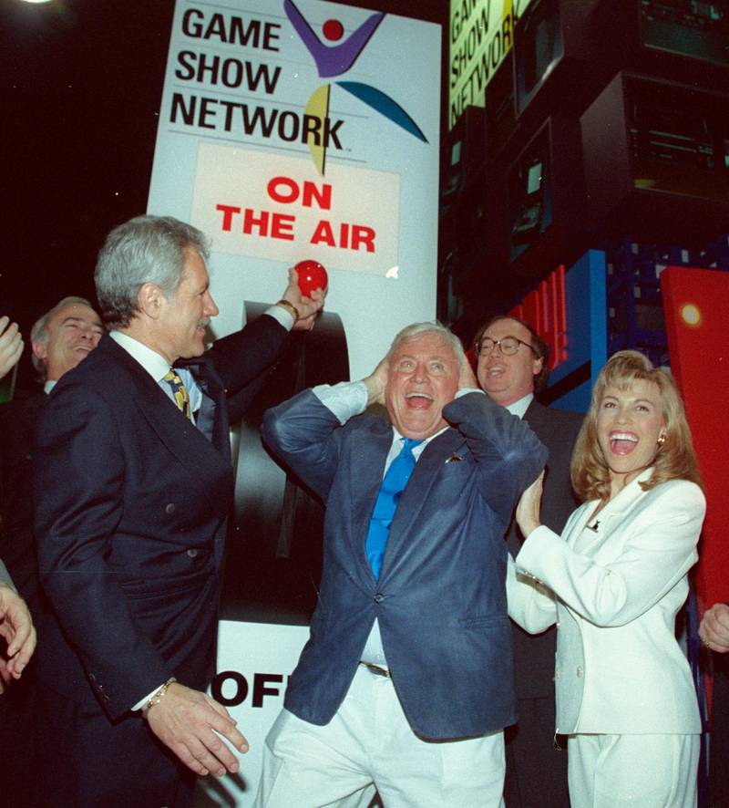 Alex Trebek, Merv Griffin, creator of 'Jeopardy' and 'Wheel of Fortune', and Vanna White, hostess on 'Wheel of Fortune,' celebrate as they turn the switch on the Game Show Network on December 1, 1994 in California. Reuters