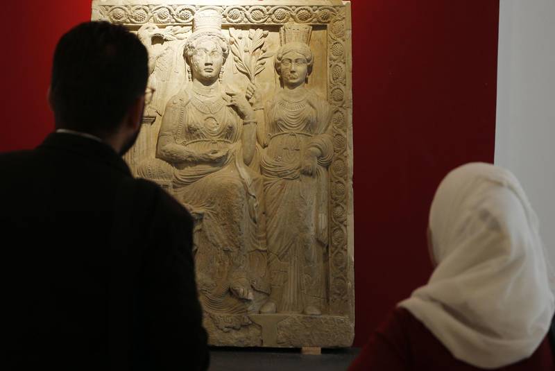 A priest and a woman visit the national antiquities museum in the Syrian capital Damascus after  on October 28, 2018.  Syria reopened a wing of the capital's famed antiquities museum today after six years of closure to protect its exhibits from the civil war. / AFP / LOUAI BESHARA
