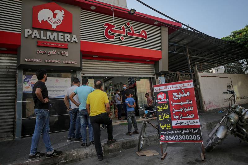 Palestinians wait to buy from a chicken shop in Gaza port, Gaza City. EPA