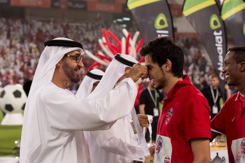 ABU DHABI, UNITED ARAB EMIRATES - May 28, 2013: HH General Sheikh Mohamed bin Zayed Al Nahyan Crown Prince of Abu Dhabi Deputy Supreme Commander of the UAE Armed Forces (L), presents a medal to an Al Ahli FC player after Al Ahli FC won the President's Cup Football Championship..( Ryan Carter / Crown Prince Court - Abu Dhabi ).---