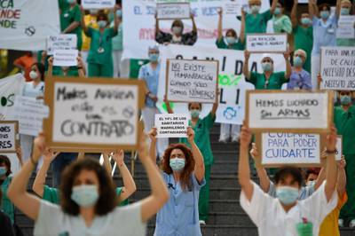A healthcare worker holds a sign reading "14 per cent of healthcare workers in Madrid are infected" during a protest calling for a reinforced healthcare system outside the Gregorio Maranon hospital in Madrid, as Spain loosens its national lockdown.  AFP