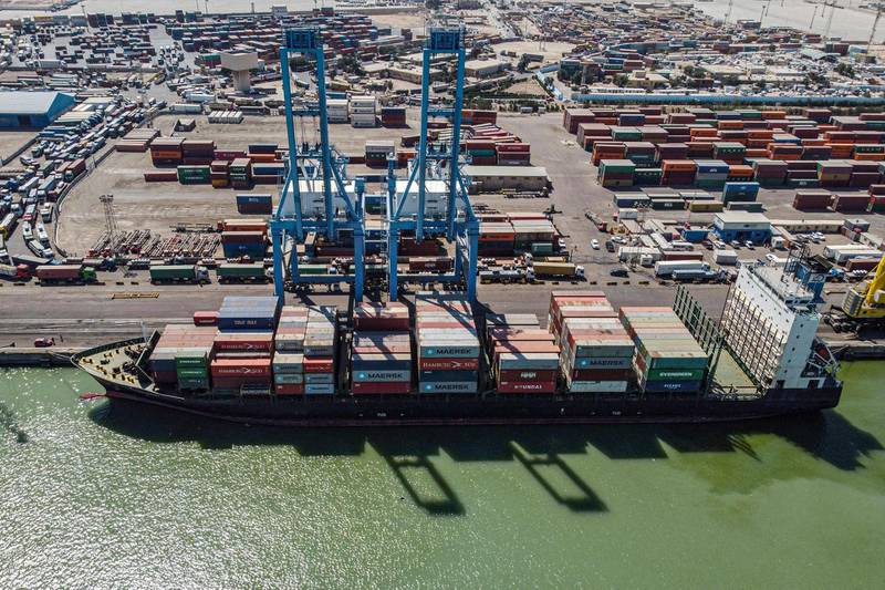 This picture taken on March 14, 2021 shows an aerial view of containers being unloaded off a cargo ship moored at the port of Umm Qasr, south of Iraq's southern city of Basra. Iraq is ranked the 21st most corrupt country by Transparency International. In January, the advocacy group said public corruption had deprived Iraqis of basic rights and services, including water, health care, electricity and jobs. It said systemic graft was eating away at Iraqis' hopes for the future, pushing growing numbers to try to emigrate. In 2019, hundreds of thousands of protesters flooded Iraqi cities, first railing against poor public services, then explicitly accusing politicians of plundering resources meant for the people. / AFP / Hussein FALEH
