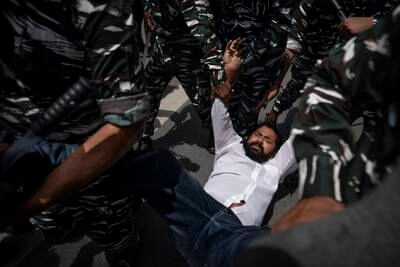 An activist is carried by paramilitary personnel in New Delhi. AP