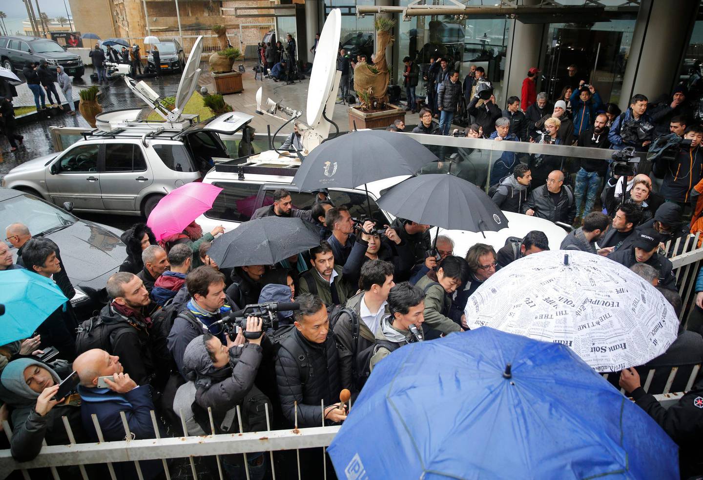 Journalists line up to enter the Lebanese Journalists Syndicate building, where ex-Nissan chief Carlos Ghosn is scheduled to hold a press conference, in Beirut, Lebanon, Wednesday, Jan. 8, 2020. The disgraced former chairman of Nissan is expected to speak to journalists in Beirut, more than a week after his dramatic escape from Japan ahead of his trial for alleged financial misconduct. (AP Photo/Hussein Malla)