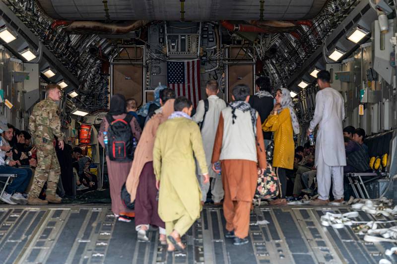 A US Air Force officer assists people aboard a C-17 Globemaster III plane at Hamid Karzai International Airport in Kabul. AFP