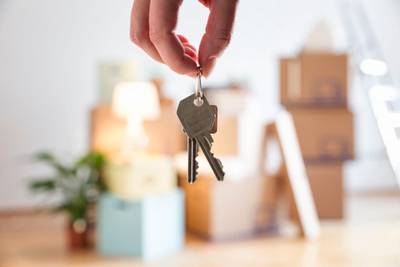 Close-up of woman holding house key in new home. Getty Images