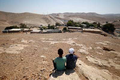 Palestinian boys sit in the Bedouin village of al-Khan al-Ahmar near Jericho in the occupied West Bank July 5, 2018. REUTERS/Mohamad Torokman