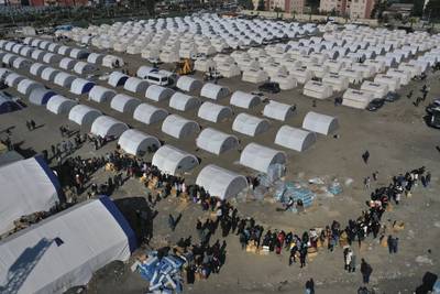 People lineup to receive aid supplies at a makeshift camp in Iskenderun city in southern Turkey. AP