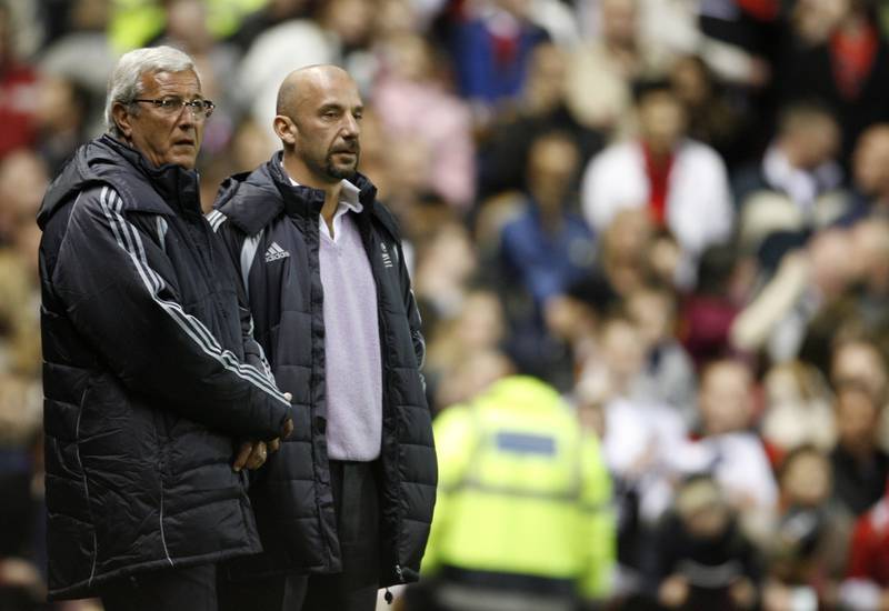 Gianluca Vialli and Europe XI coach Marcello Lippi watch before a celebration match against Manchester United to mark the 50th anniversary of Manchester United appearing in European competition. Reuters