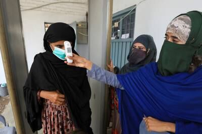 An Afghan woman has her temperature checked at a proof of registration drive at the UN refugee agency's office in Peshawar, Pakistan. Photo: Reuters