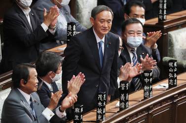 Yoshihide Suga stands up after being elected as Japan's new prime minister at parliament's lower house in Tokyo, on Wednesday, September 16, 2020. AP